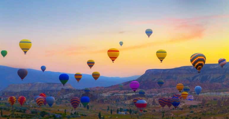 Sunset Hot air balloons landing in a mountain Cappadocia Goreme National Park Turkey.