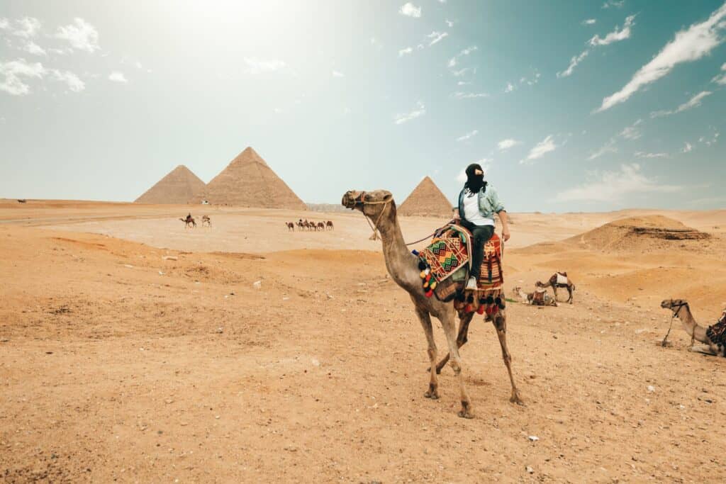 Tourist riding camel while exploring desert in Egypt