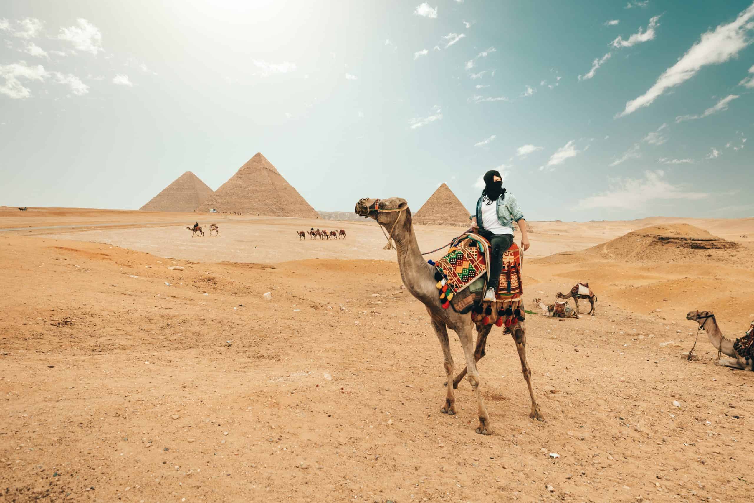 Tourist riding camel while exploring desert in Egypt