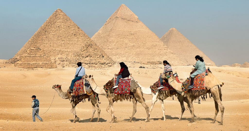 Riding on Camels Across the Pyramids